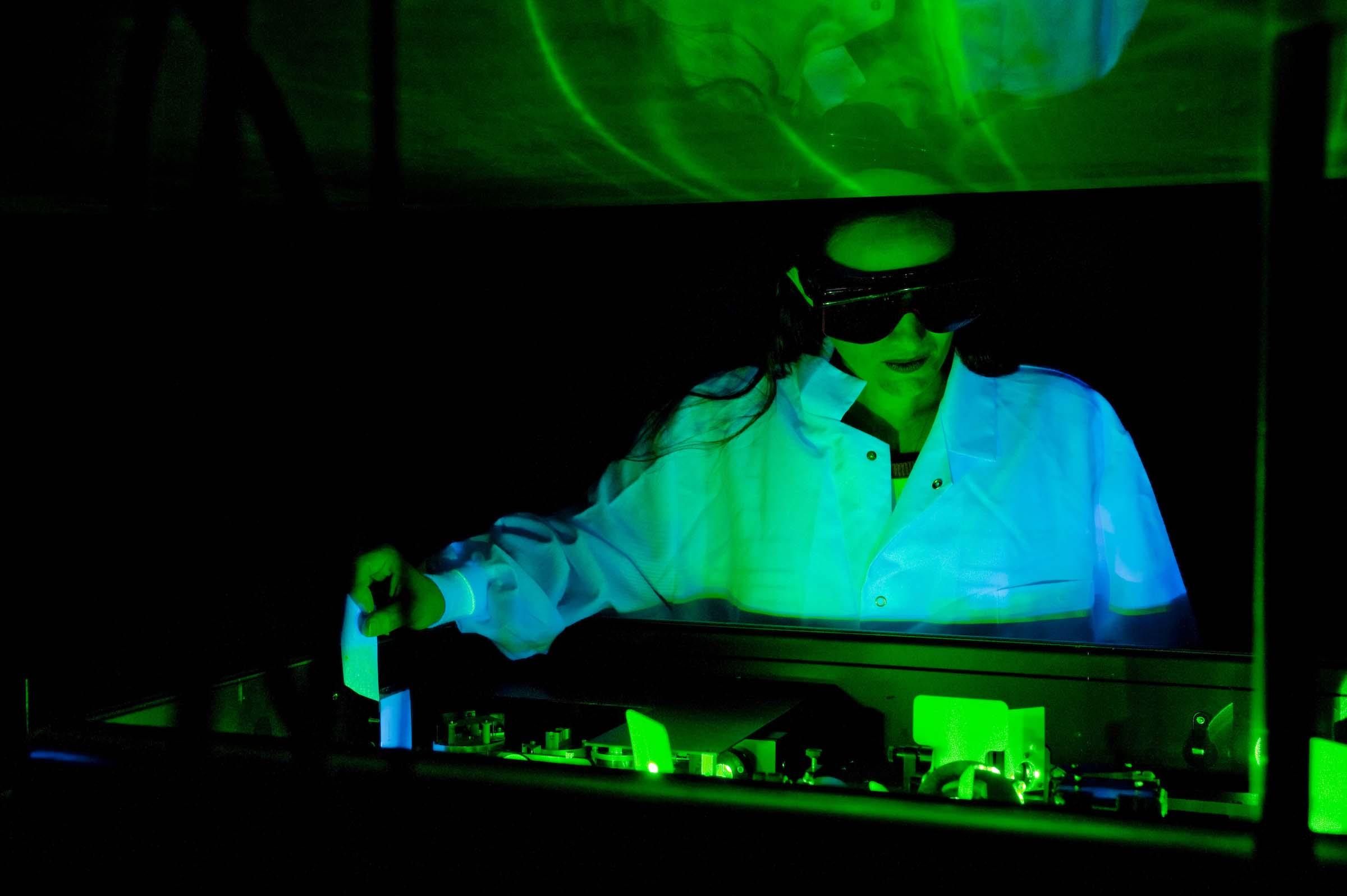 Lab assistant works with green lasers